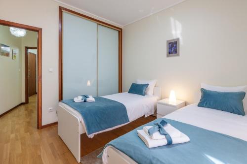 um quarto com 2 camas e toalhas em RH Charming Apartment - T3 em Barcelos