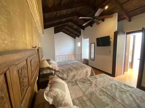 sypialnia z 2 łóżkami i wentylatorem sufitowym w obiekcie Suite don Pedro: Hermoso Loft con parqueo gratis! w mieście Antigua Guatemala