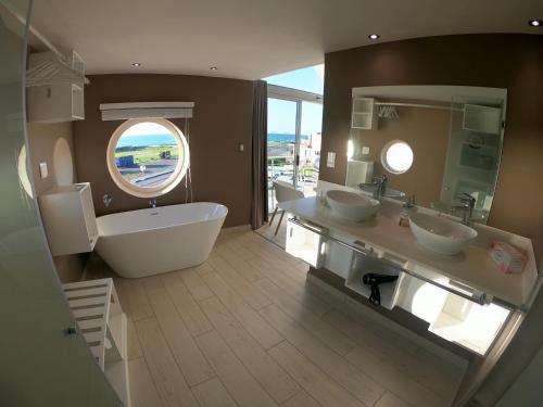 a large bathroom with two sinks and a large tub at AT THE SEA Boutique Guesthouse in Swakopmund