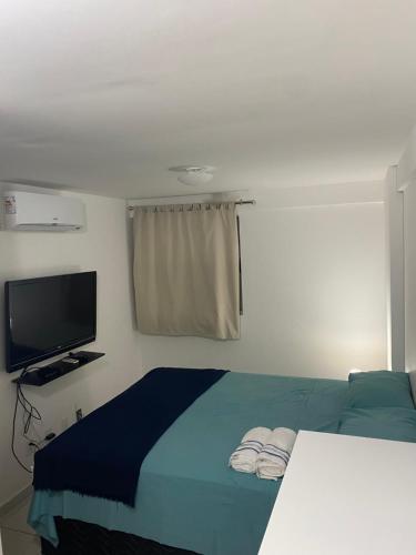 a bedroom with a bed and a flat screen tv at Apartamento 2 quartos West Flat in Mossoró