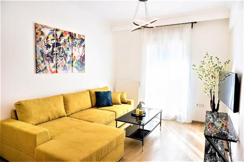 salon z żółtą kanapą i telewizorem w obiekcie Porto Sea View Apartments - A. Svolou 29 w Salonikach