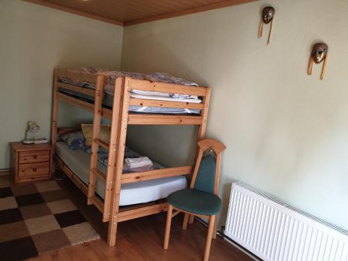 a room with a bunk bed and a chair at Lerchenhof in Friesach