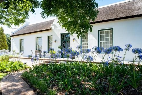 a white house with blue flowers in front of it at Laborie Jonkershuis in Paarl