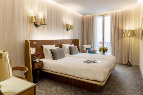 a hotel room with a large bed and a window at Maison Albar - Le Pont-Neuf in Paris