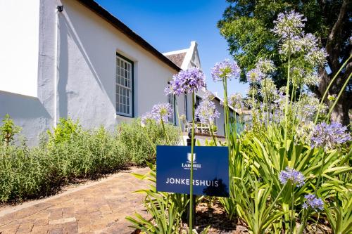 a sign in front of a church with purple flowers at Laborie Jonkershuis in Paarl