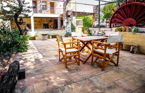 a wooden table and chairs on a patio at Mansion Argyrakiko - 3 bedroom house in Kampos in Chios