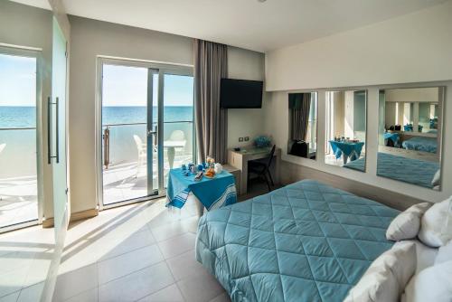 um quarto com uma cama e vista para o oceano em Smy Aran Blu Roma Mare em Lido di Ostia