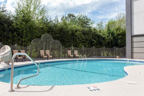 a swimming pool with chairs and a fence at Comfort Inn Asheville East-Blue Ridge Pkwy Access in Asheville