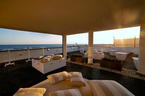 a room with beds and a balcony with the ocean at Smy Aran Blu Roma Mare in Lido di Ostia
