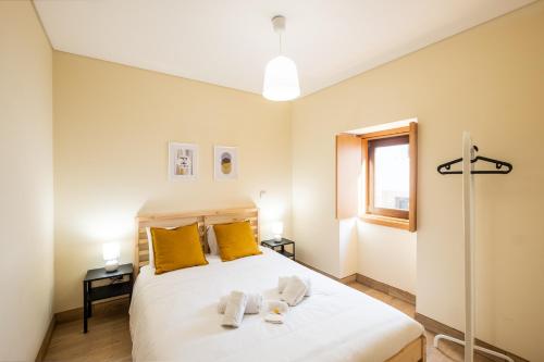 a bedroom with a large white bed with yellow pillows at #073 V3 Casa Verde by Home Holidays in Albufeira