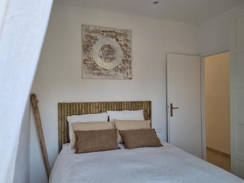 a bedroom with a bed with two pillows on it at Superbe appartement au coeur du Cap-Ferret in Cap-Ferret