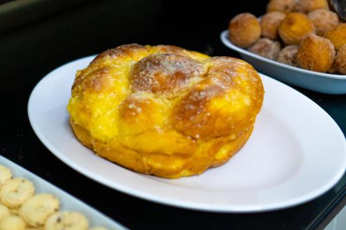 a pastry on a plate on a table with other foods at Ano Bom Palace Hotel in Barra Mansa