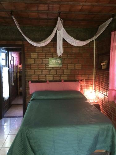 a bedroom with a bed in a brick wall at Pousada do Oasis in Morretes