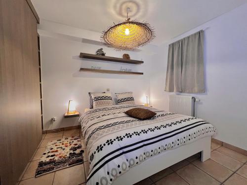 een slaapkamer met een bed en een kroonluchter bij Au travers du Hublot in Knokke-Heist