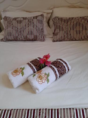 two pillows with flowers on top of a bed at The Octagon wing A in Beau Vallon