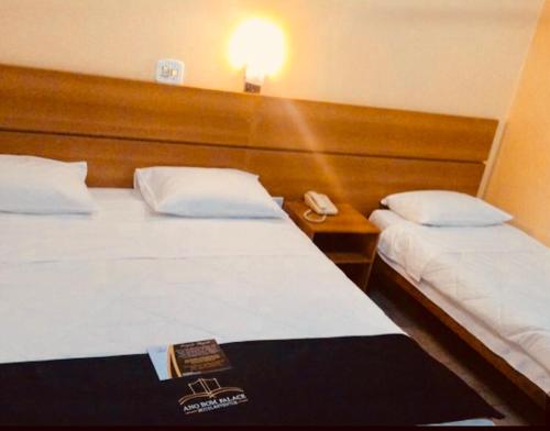 a hotel room with two beds and a telephone at Ano Bom Palace Hotel in Barra Mansa