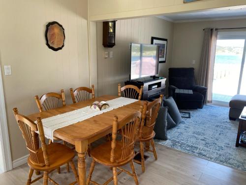 a dining room with a wooden table and chairs at Rocky Harbour Oceanfront in Rocky Harbour