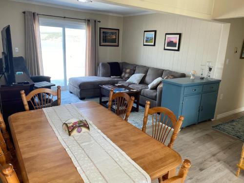 a living room with a table and a couch at Rocky Harbour Oceanfront in Rocky Harbour