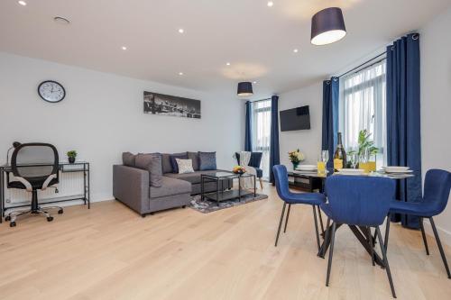een woonkamer met een tafel en een bank bij Watford Cassio Deluxe - Modernview Serviced Accommodation in Watford