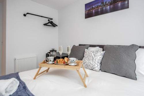 - une table basse avec un plateau de nourriture sur le lit dans l'établissement Watford Cassio Deluxe - Modernview Serviced Accommodation, à Watford