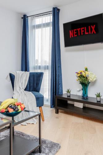 a living room with a blue chair and a table at Watford Cassio Deluxe - Modernview Serviced Accommodation in Watford