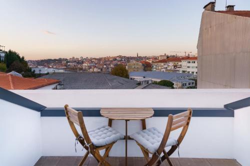 two chairs and a table on a balcony with a view at Feel Porto Wine Essence Apartments in Vila Nova de Gaia