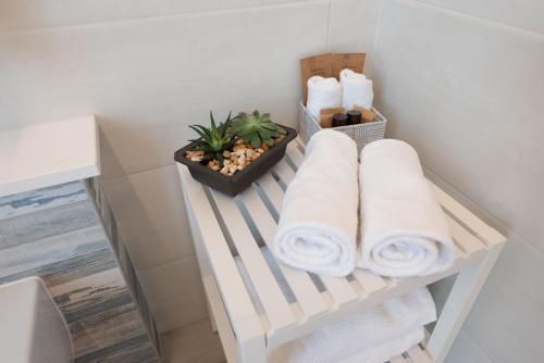 a towel rack with towels and a plant in a bathroom at La Retara Affittacamere in San Benedetto del Tronto