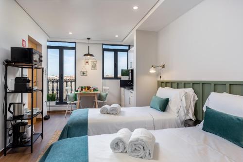 a room with two beds and a kitchen with windows at Feel Porto Wine Essence Apartments in Vila Nova de Gaia