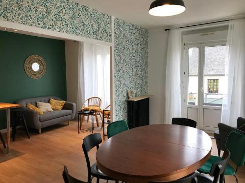 sala de estar con mesa y sofá en Maison Chiche 4 chambres indépendantes salon cuisine commune, en Bain-de-Bretagne