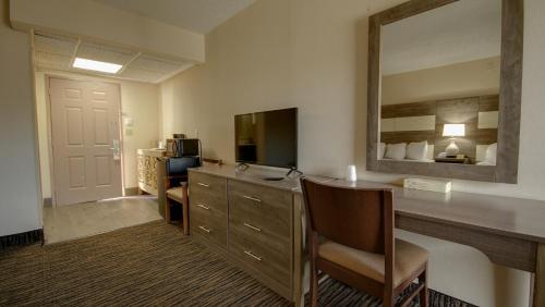 a hotel room with a desk and a mirror at Americana Motor Inn on Boardwalk in Ocean City