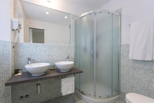 a bathroom with two sinks and a shower at Hotel Valle Verde in Procchio