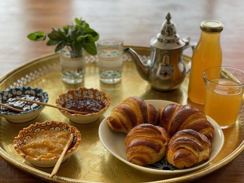a tray with croissants and other breakfast foods on a table at Touda Ecolodge Atlas Mountains in Zawyat Oulmzi