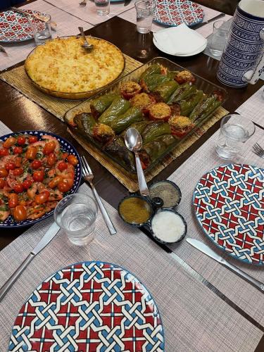 a table with plates of food and a pizza at Touda Ecolodge Atlas Mountains in Zawyat Oulmzi