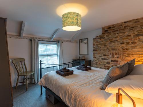 a bedroom with a bed and a brick wall at Finest Retreats - Old Harbour Cottage in Mevagissey