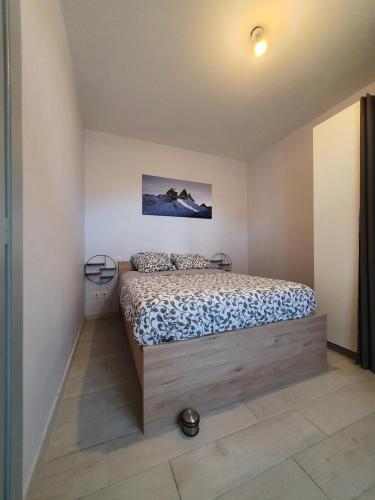 une chambre avec un lit dans une pièce dans l'établissement Appart Maurienne 2, à Saint-Jean-de-Maurienne