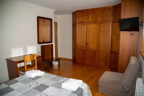 a bedroom with a bed and a desk and a chair at A Lúa do Camiño in Melide