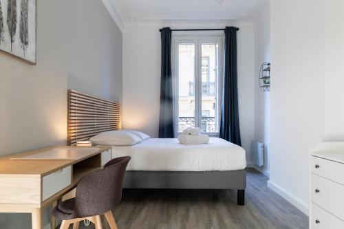 une chambre avec un lit, un bureau et une fenêtre dans l'établissement LE DIVILLIEN - Bel et grand appartement idéalement situé, à Marseille