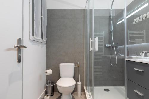 une salle de bain avec toilettes et douche en verre dans l'établissement LE DIVILLIEN - Bel et grand appartement idéalement situé, à Marseille