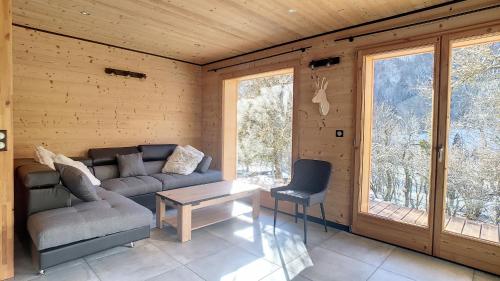 a living room with a couch and a table at Chalet BAS-THEX 8-10 pers SAINT JEAN D'AULPS- PROCHE MORZINE-WIFI in Saint-Jean-dʼAulps