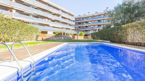 a swimming pool in front of a building at 2Kis - Lloret de Mar in Lloret de Mar