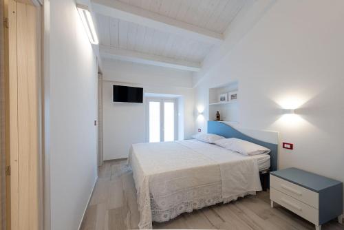 a white bedroom with a bed and a tv at La Retara Affittacamere in San Benedetto del Tronto