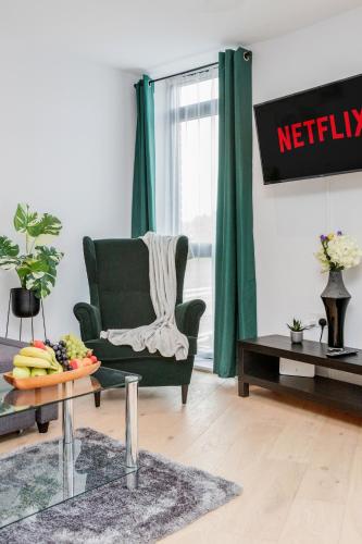 a living room with a green chair and a coffee table at Watford Cassio Luxury - Modernview Serviced Accommodation in Watford