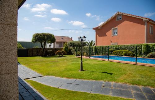 a house with a yard with a swimming pool at A Lúa do Camiño in Melide