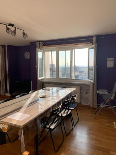 Cette chambre dispose d'une grande table en bois et d'une grande fenêtre. dans l'établissement Berck: front de mer avec vue sur la plage, à Berck-sur-Mer