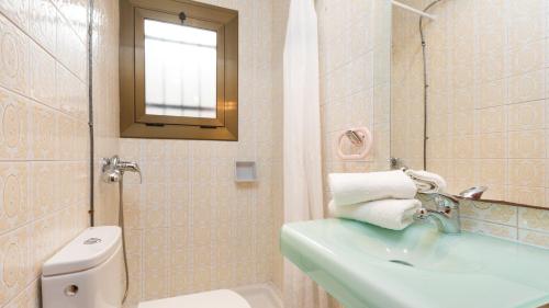een badkamer met een wastafel, een toilet en een spiegel bij 2inma01 - Lloret de Mar in Lloret de Mar