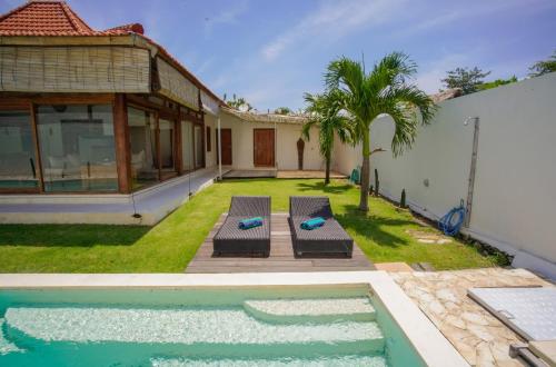 a backyard with a swimming pool and a house at Villa Ale Bingin in Uluwatu