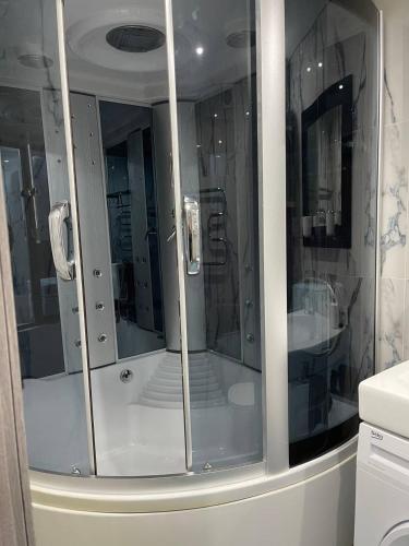 een badkamer met een douche en glazen deuren bij Люкс апартаменты, Кривой Рог, 5й Заречный, Покровский район in Krivoy Rog