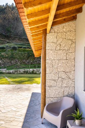 a patio with a bench and a wooden roof at Casa da Cerca - Picadeiro 1 in Braga