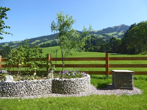 a garden in front of a fence with a tree in it at Appartement Bergrose in Hopfgarten im Brixental