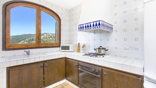 een keuken met een fornuis en een raam bij 2ibi - Lloret de mar in Lloret de Mar